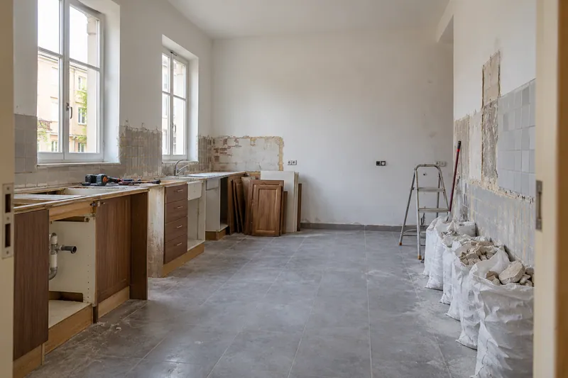 Visualización conceptual IA: Retirada de muebles y revestimientos al comienzo de una reforma de cocina.